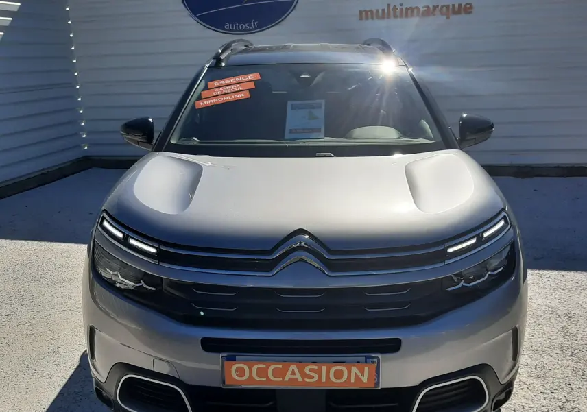 Vue frontale d'un Citroën C5 Aircross gris Artense avec toit noir, plaque "OCCASION" et phares LED distinctifs.