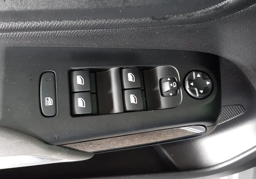 Gros plan sur les commandes des vitres et rétroviseurs côté conducteur d'une Citroën C5 Aircross gris Artense avec toit noir.