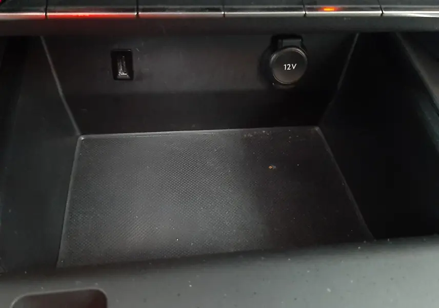 Gros plan sur la console centrale noire du Citroën C5 Aircross 1.2 PureTech, avec prise 12V et port USB visibles.