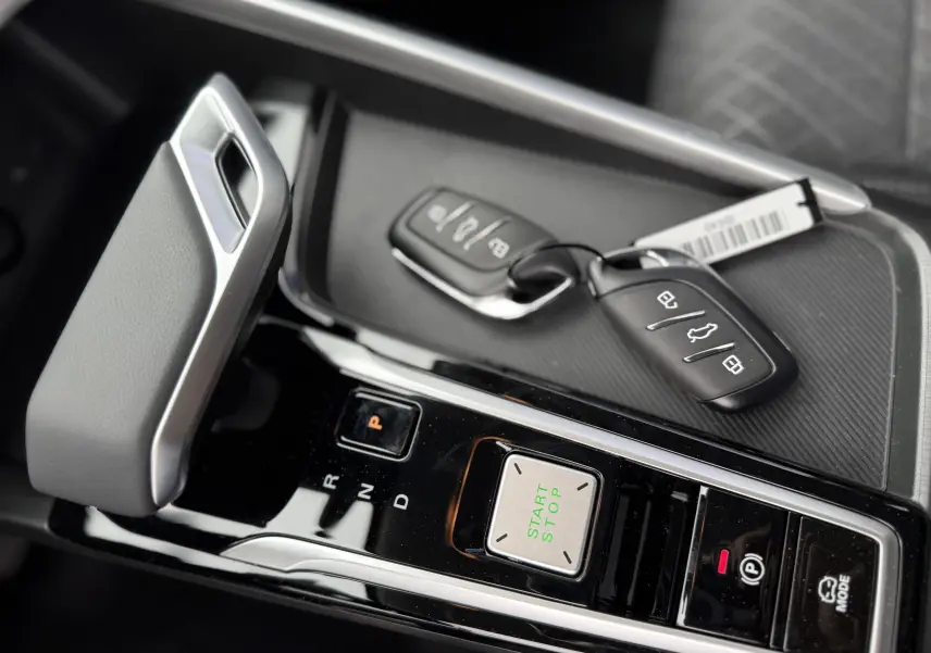 Gros plan sur la console centrale du MG ZS 1.5L Hybrid+ 2026 avec levier de vitesse, bouton start/stop et clés posées.