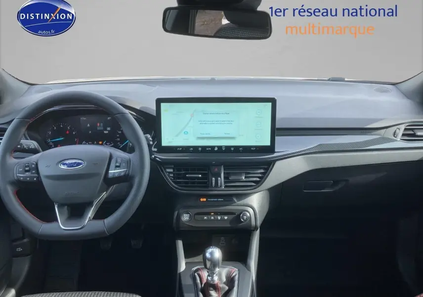 Vue intérieure avant de la Ford Focus gris, volant 3 branches avec coutures rouges et écran tactile central 13,2 pouces.