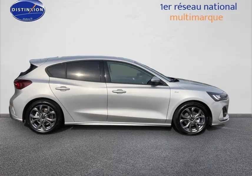 Profil latéral droit d'une Ford Focus gris métallisé 2025 avec jantes alu et vitres arrière surteintées.