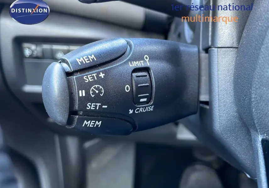 Gros plan sur la commande de régulateur de vitesse du Citroën C5 Aircross hybride, intérieur noir.