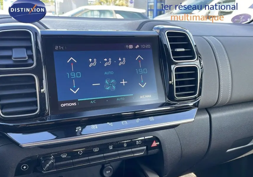 Vue rapprochée de la console centrale du Citroën C5 Aircross blanc nacré, avec écran tactile et commandes de climatisation.