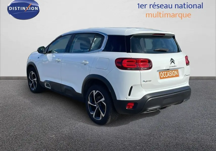 Vue 3/4 arrière droite d'un Citroën C5 Aircross blanc nacré hybride avec jantes bi-ton et toit noir.