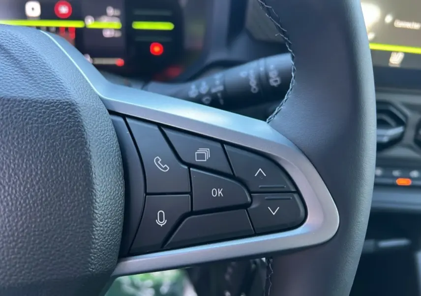 Gros plan sur les commandes au volant du Dacia Duster 2025, version Mild Hybrid 130 4x4 Expression, avec finition noire et argentée.