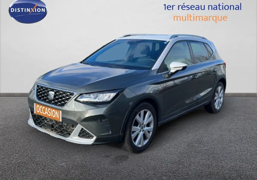 Vue 3/4 avant droite d'une SEAT Arona gris falaise métal avec toit blanc et jantes argentées.