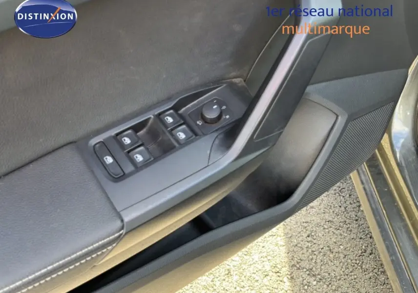 Détail des commandes de lève-vitres et rétroviseurs sur la portière côté gauche d’un SEAT Arona gris falaise métal.