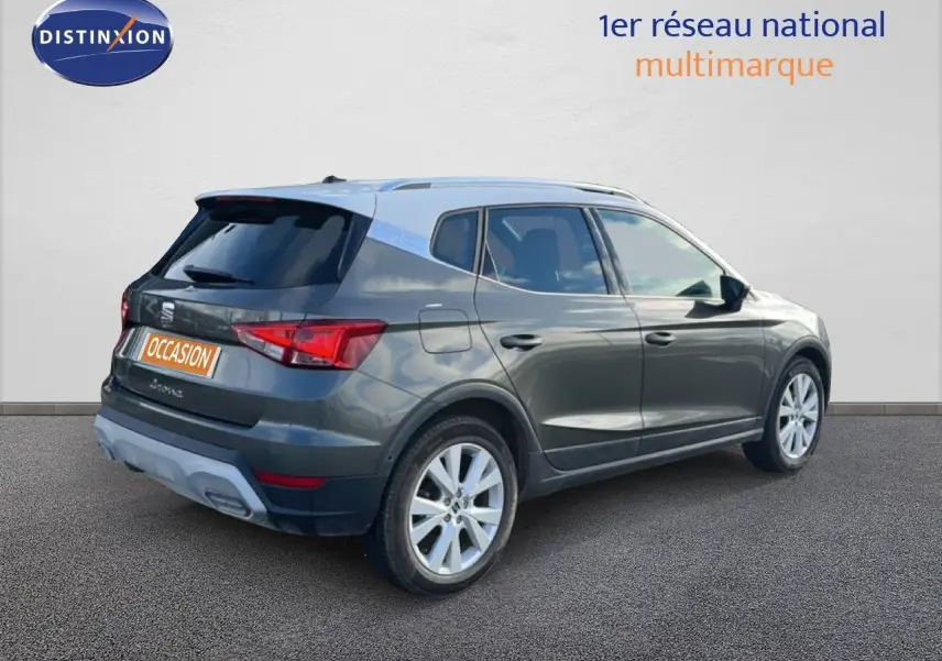 Vue 3/4 arrière droite d'une SEAT Arona gris falaise métal avec toit blanc, roues alliage et feux arrière LED.