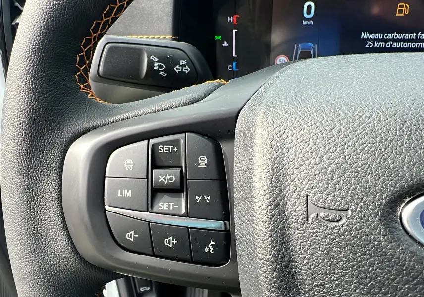 Gros plan sur le volant cuir multifonctions du Ford Ranger blanc glacier avec commandes de régulateur et audio.