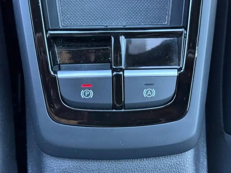 Gros plan sur les boutons de frein de stationnement et d'arrêt automatique dans l'habitacle de l'Audi Q2 35 TDI S line 2025.