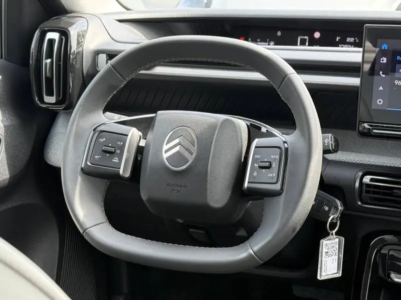 Vue rapprochée du volant gris de la Citroën C3 1.2 Turbo 2025 avec commandes intégrées et tableau de bord moderne.