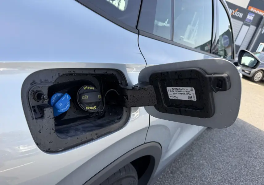 Vue rapprochée de la trappe à carburant ouverte côté gauche du Volkswagen Tiguan gris, montrant les bouchons Diesel et AdBlue.