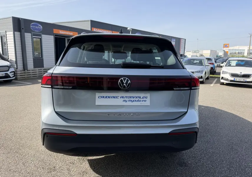 Vue arrière d’un Volkswagen Tiguan gris 2025 avec feux arrière LED traversants et logo VW centré.