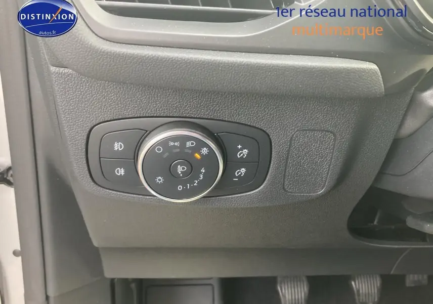 Gros plan sur le tableau de bord côté gauche de la Ford Focus gris, avec commandes d'éclairage et pédales visibles.