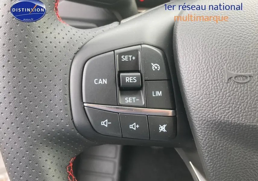 Gros plan sur le volant perforé noir avec coutures rouges et commandes de régulateur de vitesse de la Ford Focus 2025.