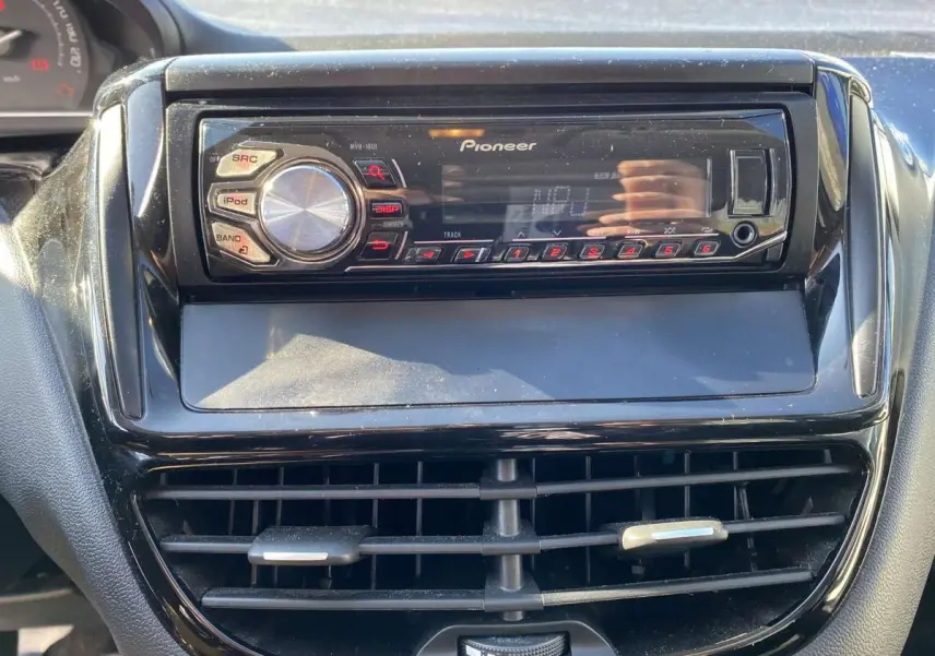 Autoradio Pioneer intégré au tableau de bord noir du Peugeot 208 2015, avec commandes et écran digital visibles.