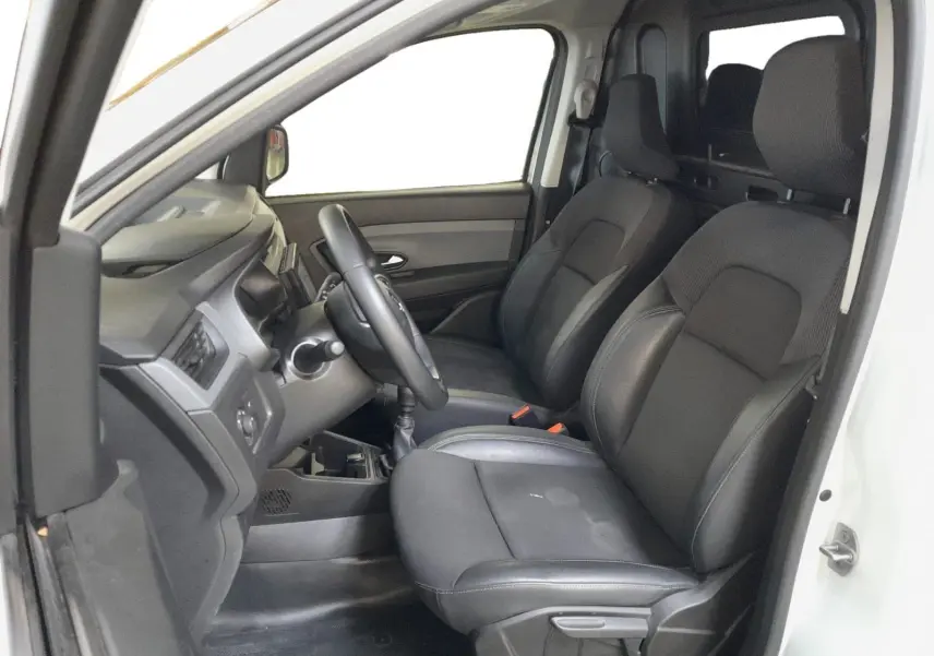 Intérieur du Renault Express Van blanc 2023, vue côté conducteur, sièges noirs en tissu et tableau de bord simple.