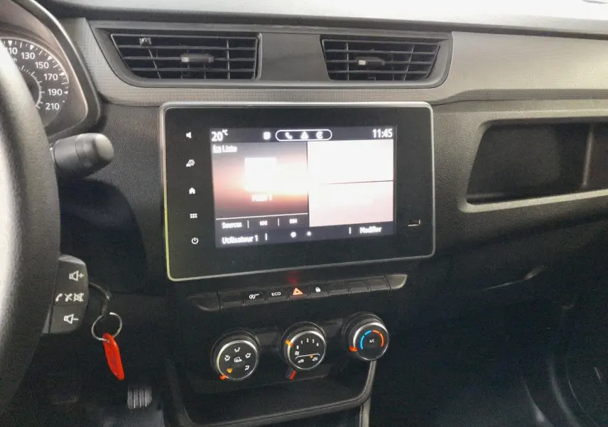 Vue rapprochée du tableau de bord noir du Renault Express Van 2023 avec écran tactile et commandes manuelles de climatisation.