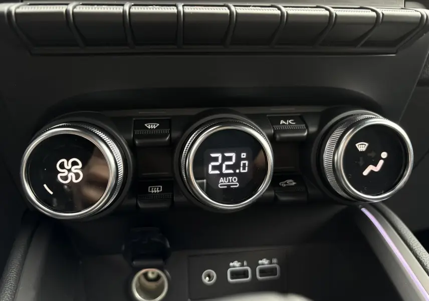 Commandes de climatisation avec affichage digital à 22°C et éclairage d'ambiance violet dans la Renault Clio Gris Rafale.