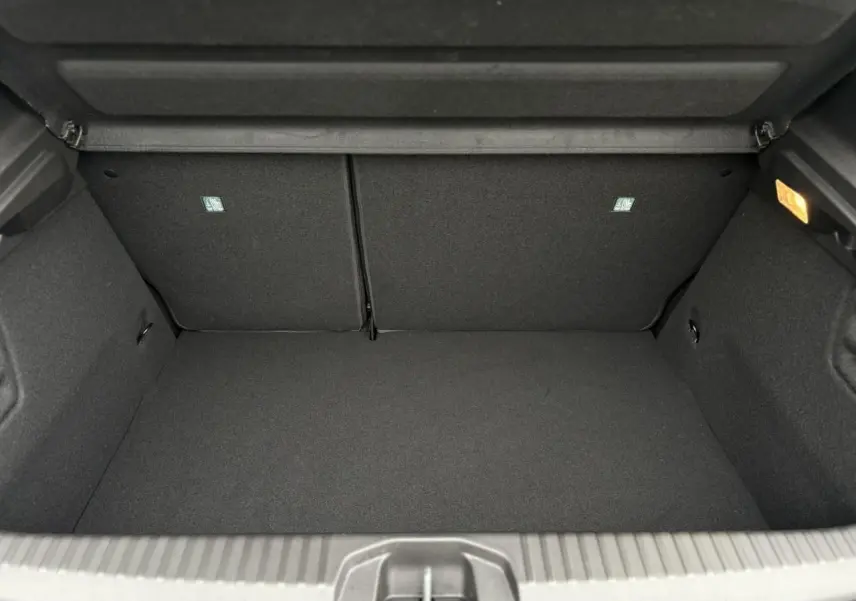 Coffre ouvert noir de la Renault Clio V NV E-Tech Full Hybrid 2025, montrant un espace de rangement propre et éclairé.