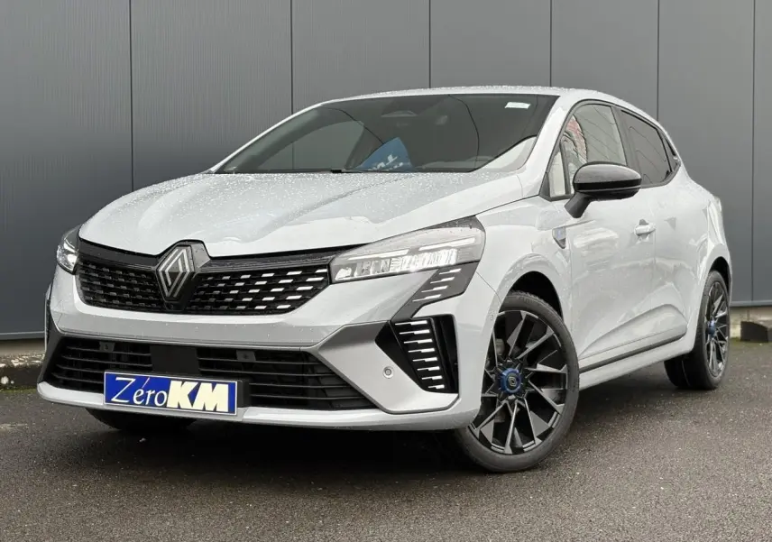 Renault Clio Gris Rafale vue 3/4 avant droit, avec calandre noire et jantes alliage noires distinctives.