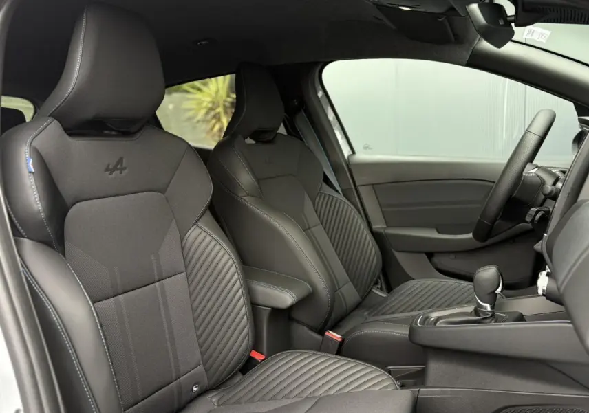 Vue intérieure côté droit des sièges sport noirs avec surpiqûres bleues et logo Alpine sur Renault Clio Esprit Alpine 2025