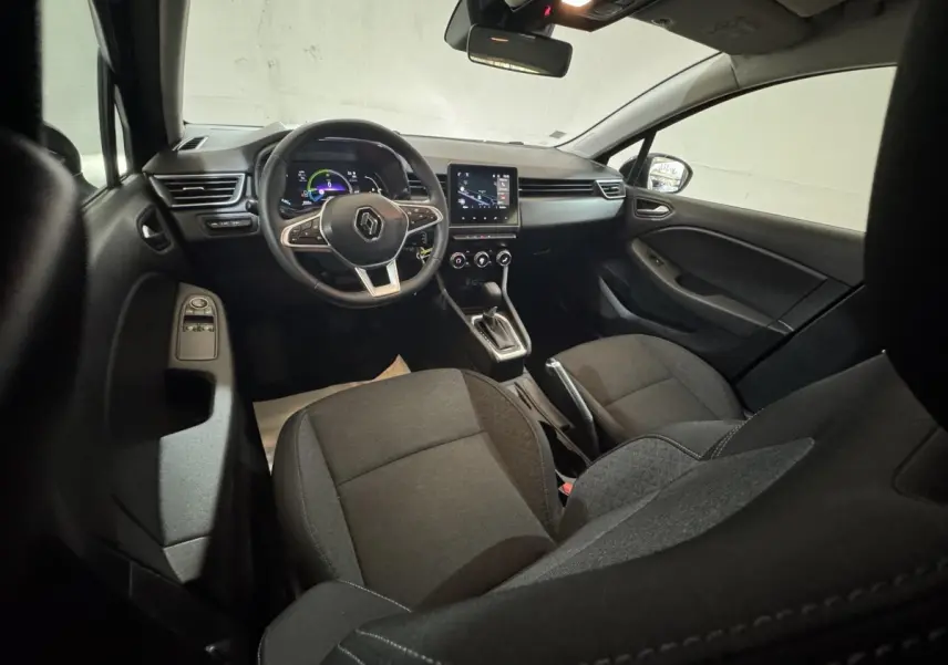 Vue intérieure avant droite de la Renault Clio Business E-Tech hybride 2021 avec sièges noirs et tableau de bord numérique.
