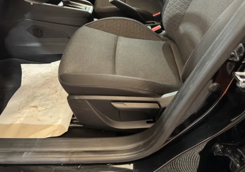 Vue rapprochée du siège avant droit noir en tissu de la Renault Clio Business E-Tech hybride 2021, porte ouverte.