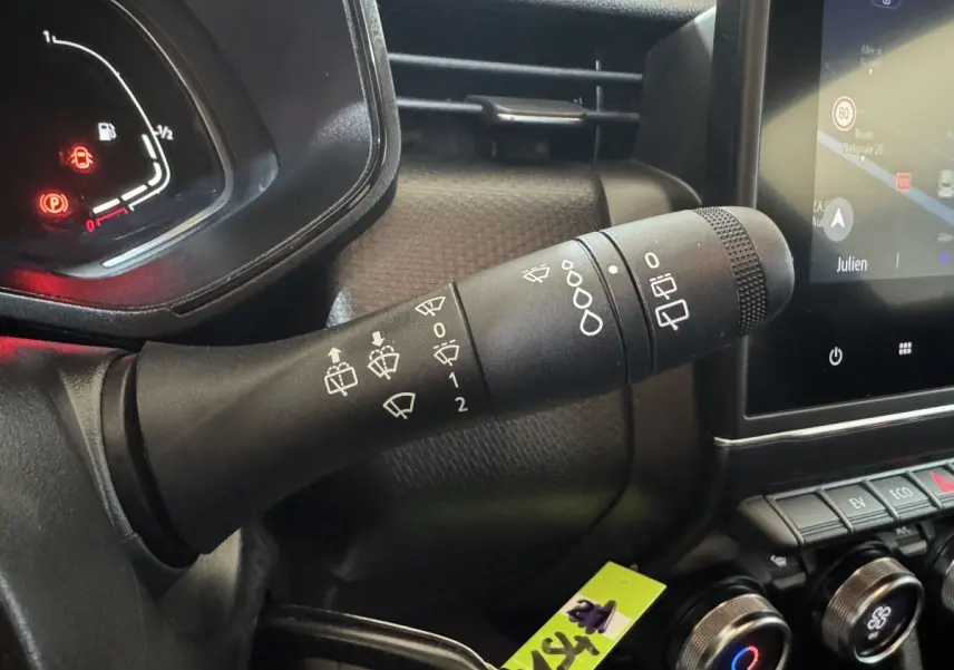 Gros plan sur la commande des essuie-glaces à gauche du volant dans l’habitacle noir de la Renault Clio Business E-Tech hybride 2021.