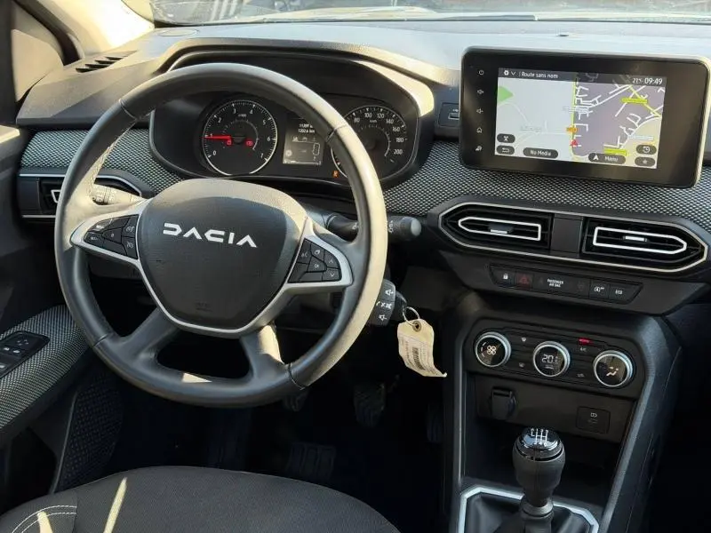 Vue intérieure centrée sur le volant Dacia et tableau de bord avec écran tactile et boîte manuelle du Jogger gris Schiste.