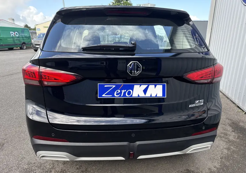 Vue arrière du MG ZS hybride noir Pebble Black Metal avec feux rouges et logo MG bien visibles.