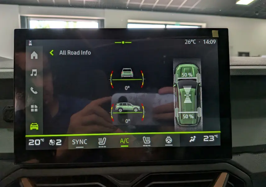 Écran tactile intérieur du Dacia Bigster Hybrid-G 150 4x4 gris schiste montrant l'info traction et climatisation.