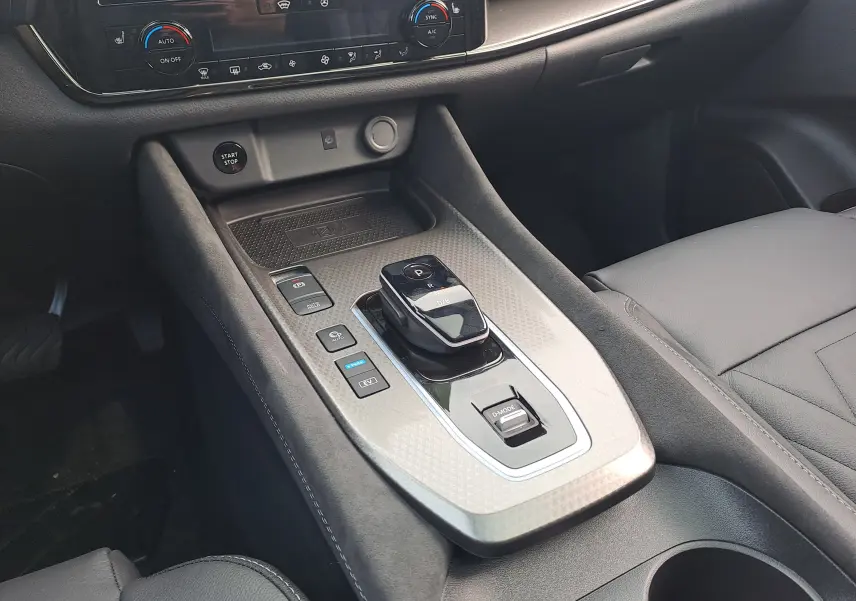 Console centrale en intérieur noir du Nissan Qashqai 2025 avec levier de boîte automatique et commandes de mode de conduite.