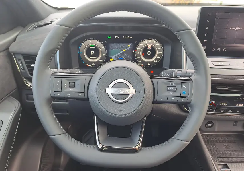 Vue rapprochée du volant cuir noir et du tableau de bord numérique du Nissan Qashqai 2025, intérieur moderne.