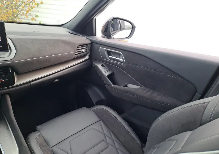 Intérieur noir du Nissan Qashqai 2025, vue côté passager avant avec sièges et garnitures en cuir et alcantara.