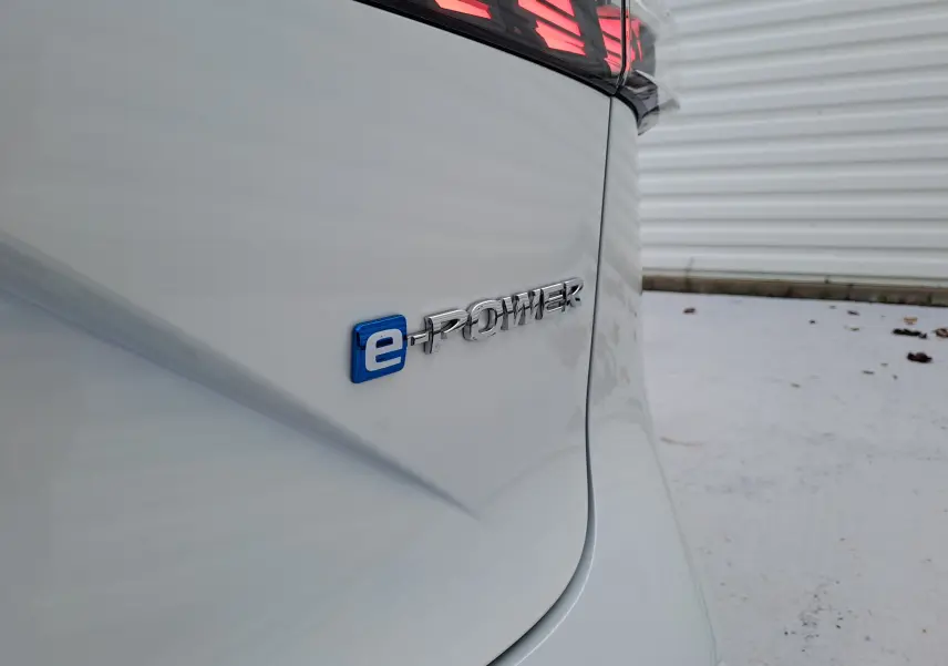 Gros plan sur l'arrière blanc nacré du Nissan Qashqai 2025 avec le badge e-POWER bleu et chrome visible.