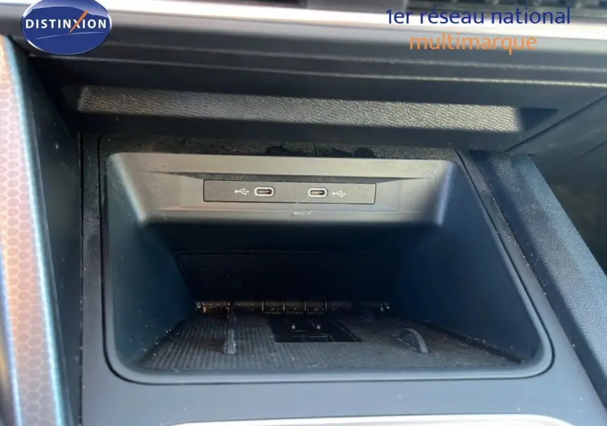 Gros plan sur la console centrale intérieure du SEAT Leon 2025, montrant deux ports USB-C dans un espace de rangement noir.