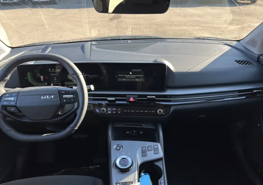 Vue intérieure du tableau de bord du Kia Sportage 2026 gris eclipse, avec volant multifonctions et écran tactile large.