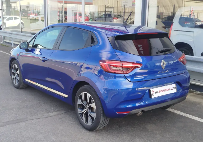 Renault Clio 1.0 SCe 65ch Evolution bleu Iron vue 3/4 arrière droit, jantes alliage et vitres teintées.
