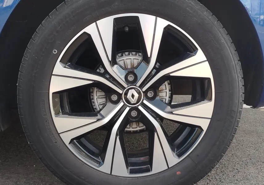 Gros plan sur la jante alliage bicolore noire et argentée d’une Renault Clio Bleu Iron 2022.