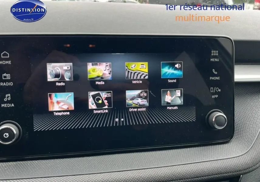 Écran tactile central affichant le menu multimédia dans l'habitacle d'une Skoda Fabia blanche, vue de face.