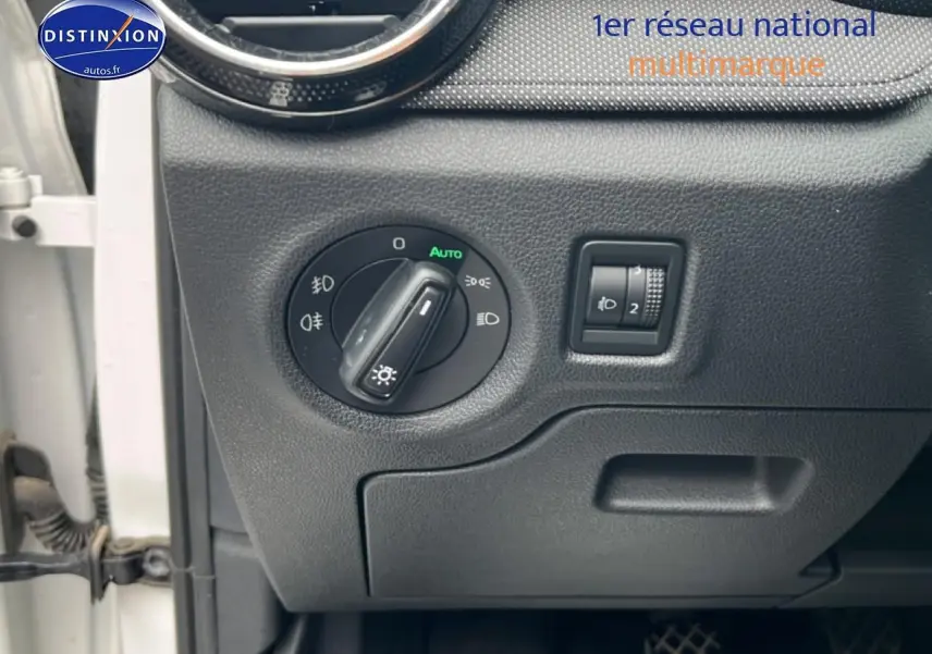 Détail du tableau de bord côté gauche d’une Skoda Fabia blanche 2025, avec commandes d’éclairage et réglage phares.