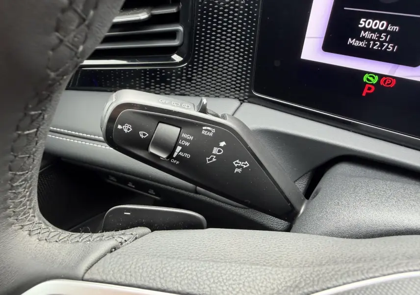 Gros plan sur la manette de commande des essuie-glaces et clignotants du Volkswagen Tiguan 2025, intérieur noir.