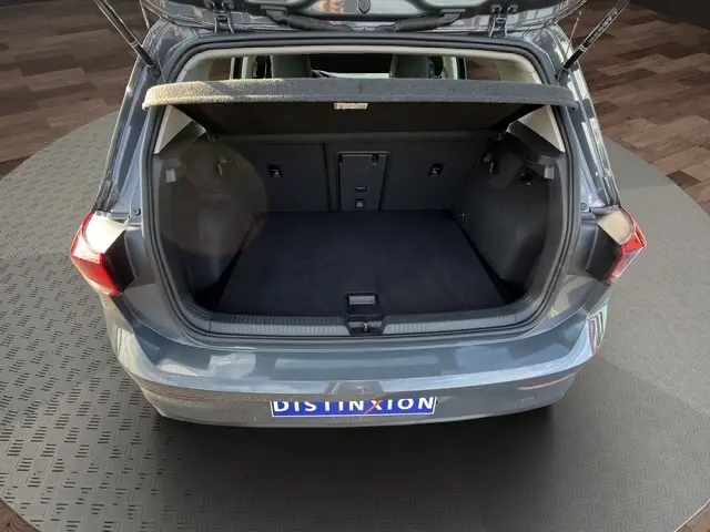 Vue arrière ouverte sur le coffre spacieux d'une Volkswagen Golf gris clair 2023, avec tablette cache-bagages relevée.