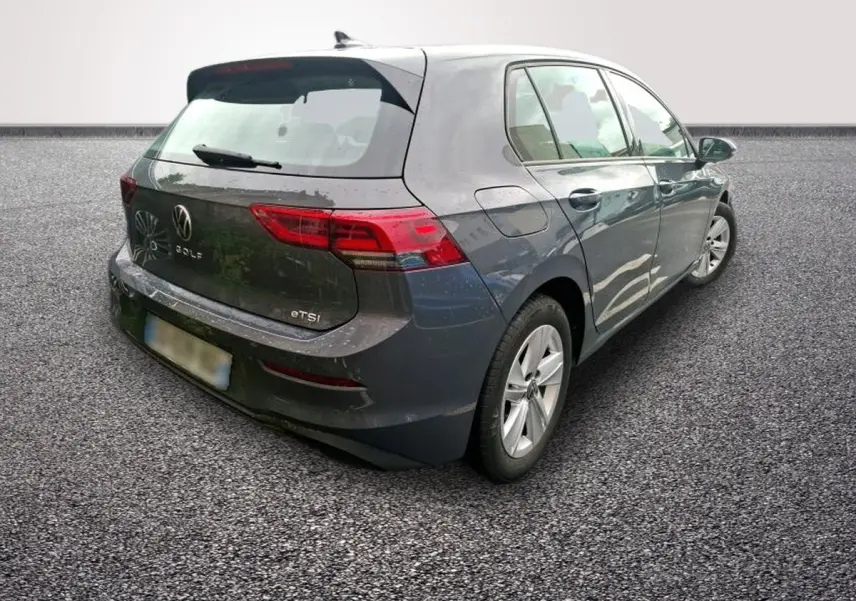 Volkswagen Golf gris clair vue 3/4 arrière droit, avec feux LED et logo VW visible sur le hayon.