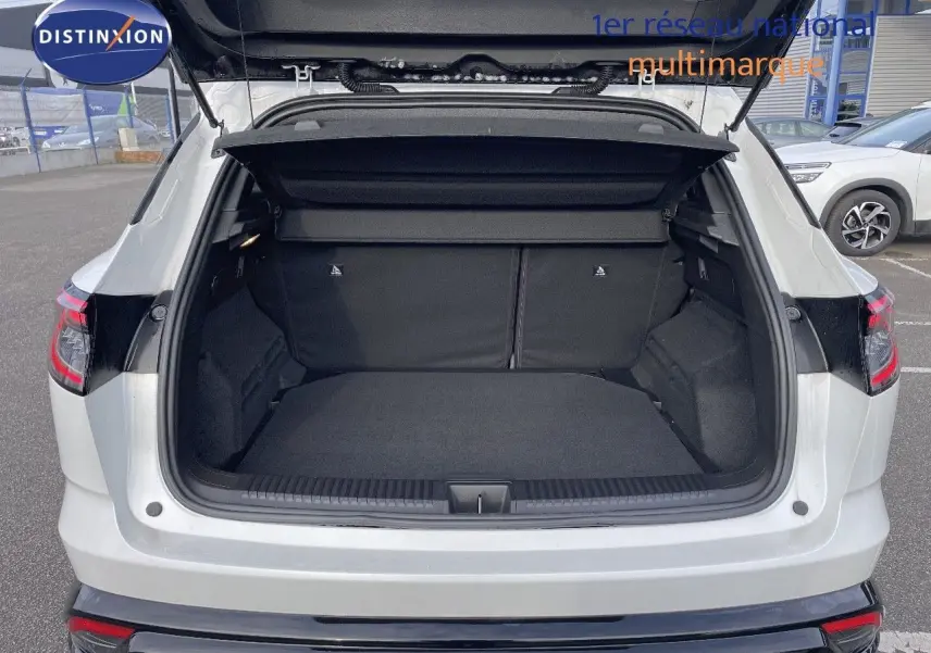 Coffre ouvert vu de l'arrière d'un Renault Austral blanc nacré, soulignant l'espace de chargement généreux.