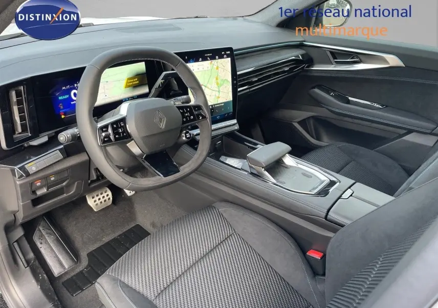 Intérieur avant droit du Renault Austral 2025 hybride, avec tableau de bord numérique et écran tactile central moderne.