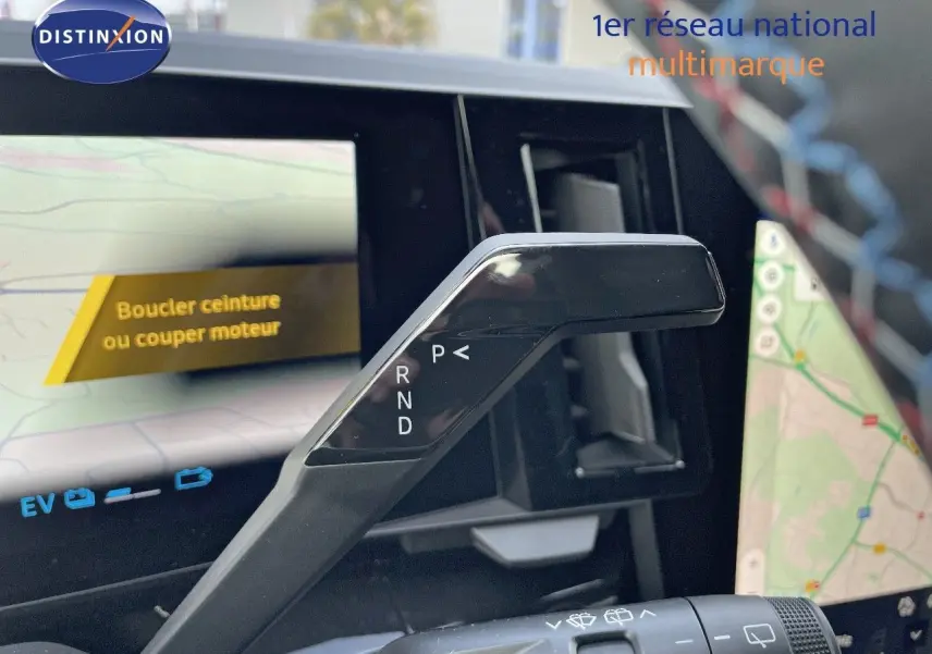 Le levier de vitesses automatique noir du Renault Austral E-Tech, avec écran tactile affichant la navigation en arrière-plan.