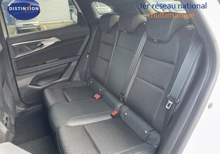 Vue côté gauche des sièges arrière noirs en tissu et cuir du Renault Austral blanc nacré 2025, avec surpiqûres bleues.